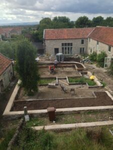 Garden being renovated; empty raised beds and gravel in