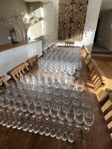 Large wooden table full of glasses