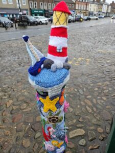 Yarn bombers showing sea side scene