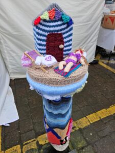 Yarn bombers showing knitted sea side scene