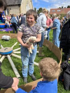 Young boy smiling and holding white feret at village show