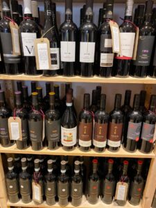 Wooden shelves displaying bottles of red wine with labels in Helmsley Wine