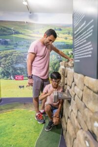 Man and young boy exploring a dry stone wall at Dalby Visitor Centre