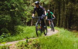 Two men on mountain bikes riding on a trail through Dalby Forest