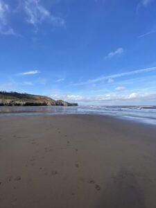 Emptu sandy beach with tide out underneath a blue sky