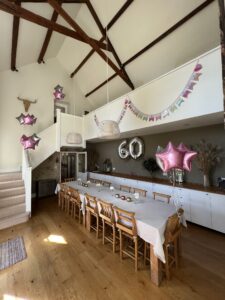 The dining room with high beamed ceiling, dressed with pink and silver balloons and bunting