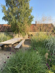 Long oak table with wooden benches in Long Barn courtyard garden