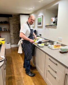 Male chet in apron preparing meal in the kitchen. 