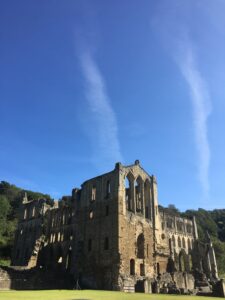 Rievaulx abbey ruin with blue sky behind