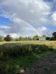 Rainbow over the green and white Reading Room in Appleton Le Moors