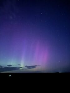 Purple and pink aurora in night sky