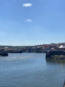 View from sea looking into a harbour with blue sky