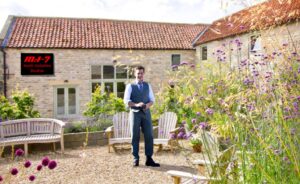 Man standing in gravelled garden,