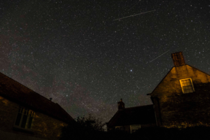 Stars in night sky about farmhouse and barn