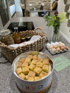 Welcome hamper with a tin of lemon drizzle cake and fresh eggs.