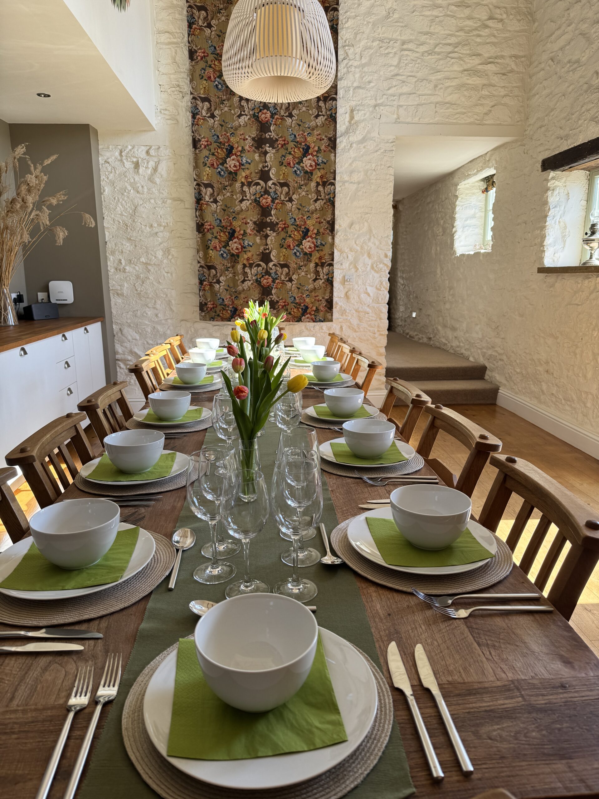 Dining Table set for diiner with green runner and bright colouted tulips