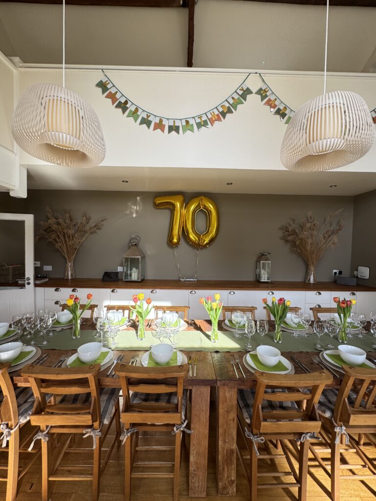 Gold 70th balloons in dinning room with table set for dinner