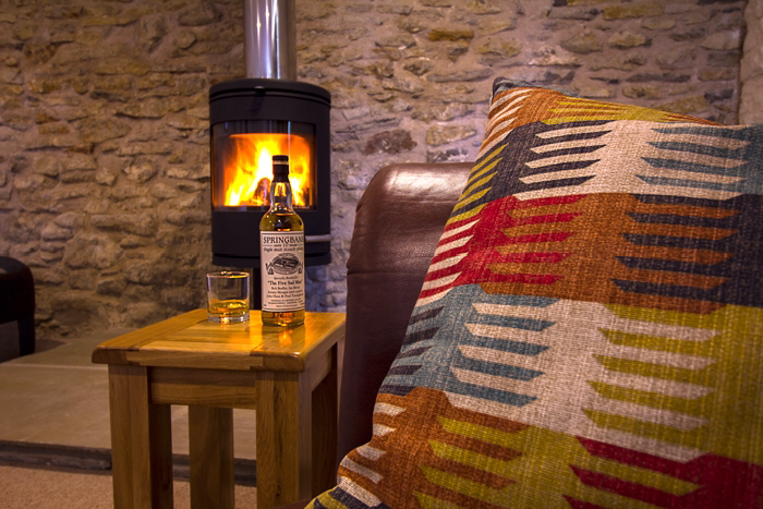 A cozy fire and a glass of whisky at The Long Barn, the perfect setting for a childish grown-up to relax and rediscover simple pleasures.