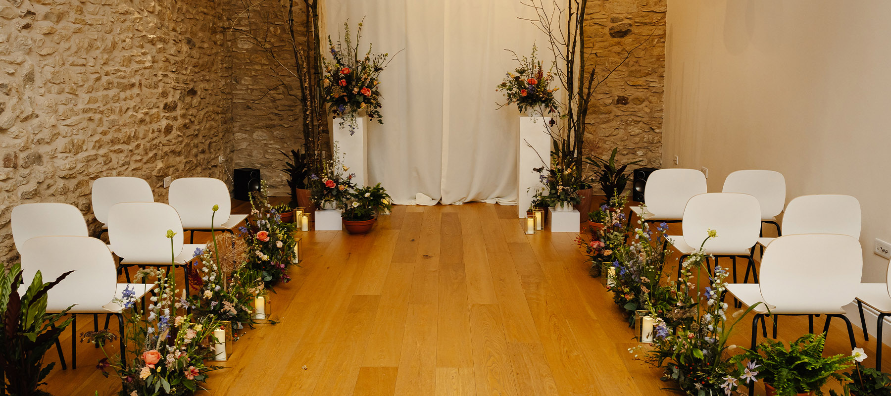 Long Barn, North York Moors intimate wedding ceremony space with floral aisle arrangements and seating for an intimate celebration